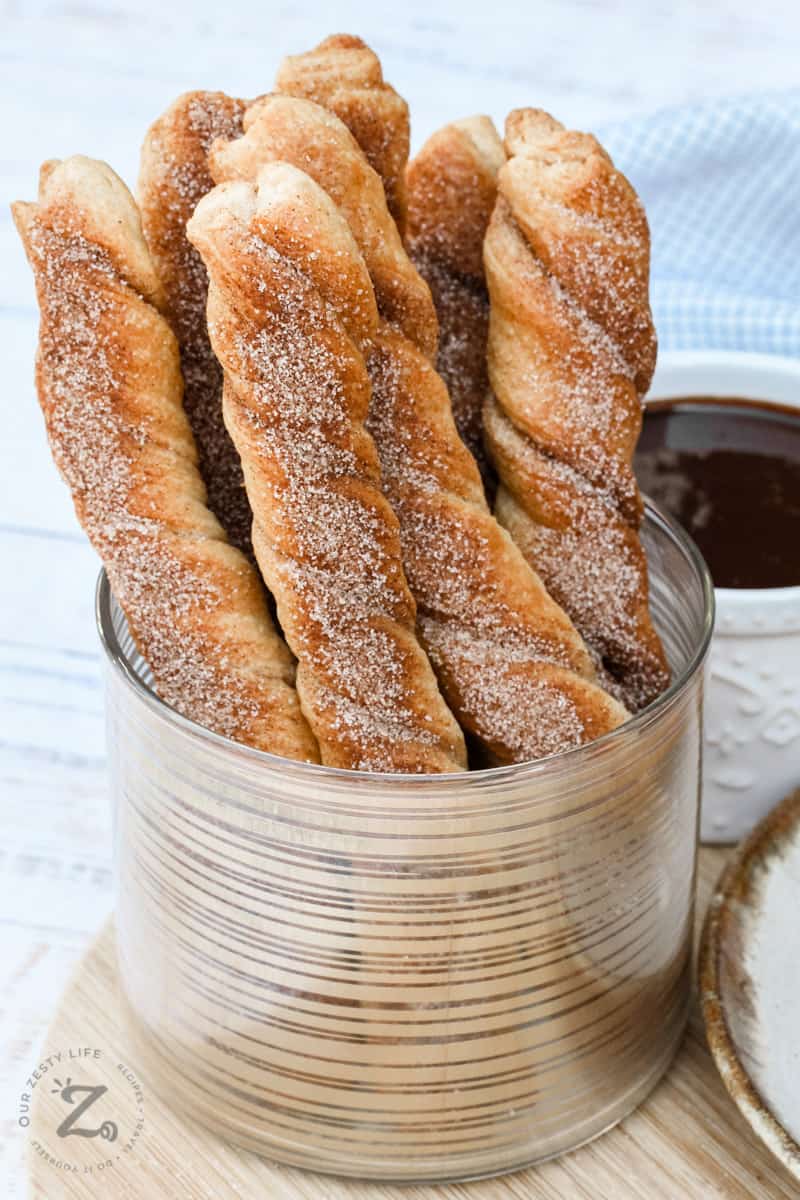 Baked Churros standing upright in a dish