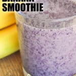 Blueberry Banana Smoothie in a glass with bananas and blueberries on the side with a title