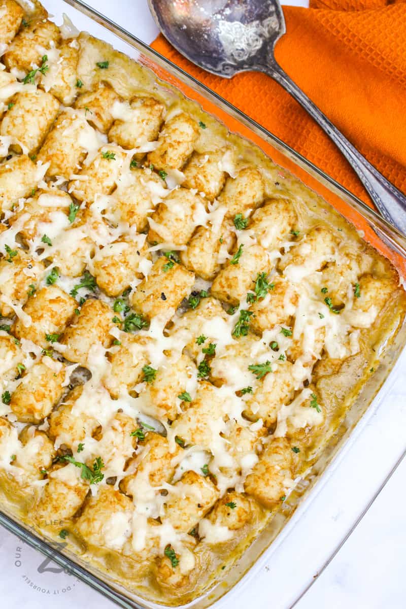 baked Cheesy Tater Tot Casserole with an orange napkin and spoon
