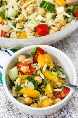 Orzo Pasta Salad in a white bowl with a spoon