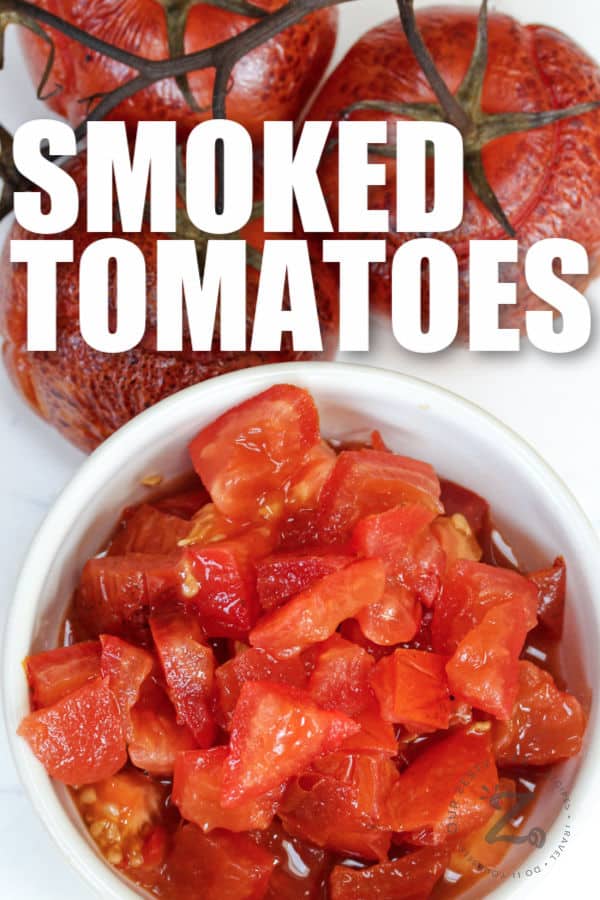 diced tomatoes in a white bowl with tomatoes behind it and writing
