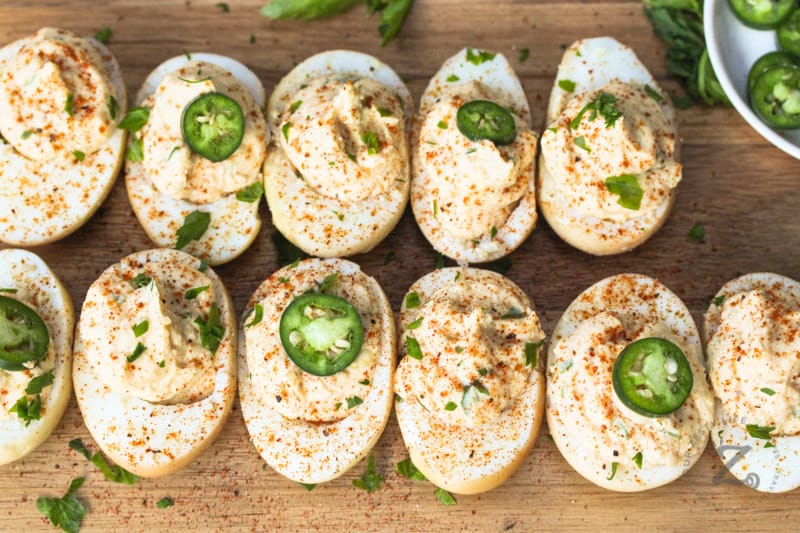 Smoked Deviled Eggs on a cutting board and garnished