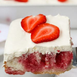 slice of Strawberry Poke Cake being put on a plate