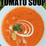 bowl of Creamy Tomato Soup with croutons cheese and basil with writing