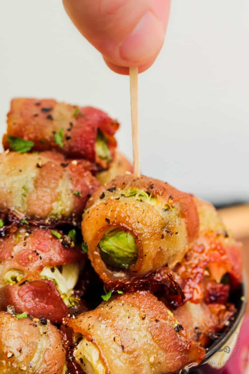 sticking a toothpick into Bacon Wrapped Brussel Sprouts