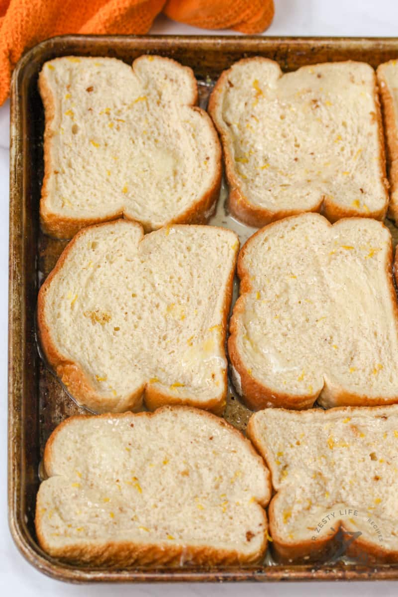 soaked bread on a baking sheet to make French Toast