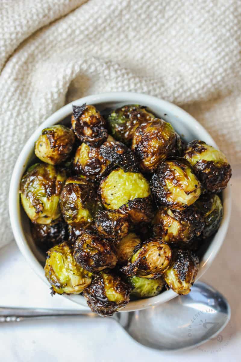 bowl of Air Fryer Brussels Sprouts with spoon beside it