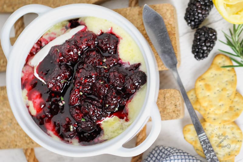 Baked Brie with Berries in a cup with crackers and berries around it