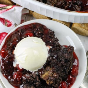 plated Chocolate Cherry Dump Cake with dish full in the back