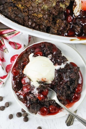 Chocolate Cherry Dump Cake on a plate with ice cream and a fork