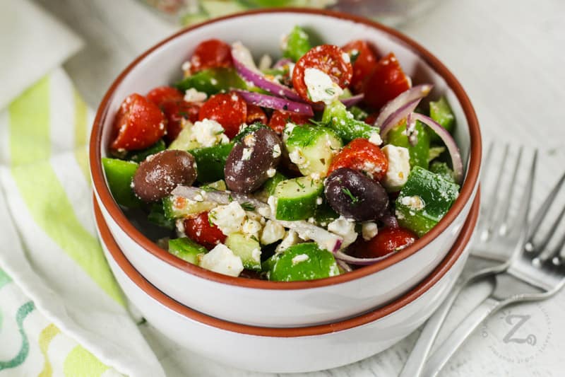 Greek Salad in a bowl with forks beside it