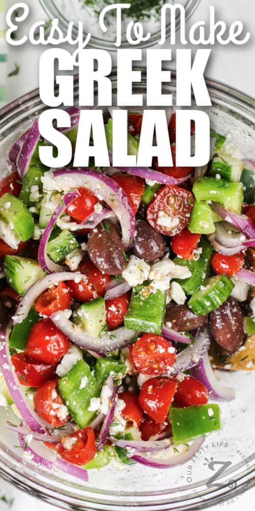 close up of Greek Salad in a glass bowl with a title