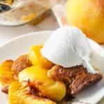 plated Peach Cobbler with the casserole dish in the back