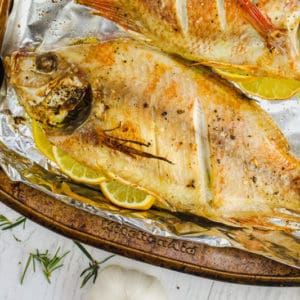 Baked Whole Fish cooked on a baking sheet with lemon garlic salt and seasonings
