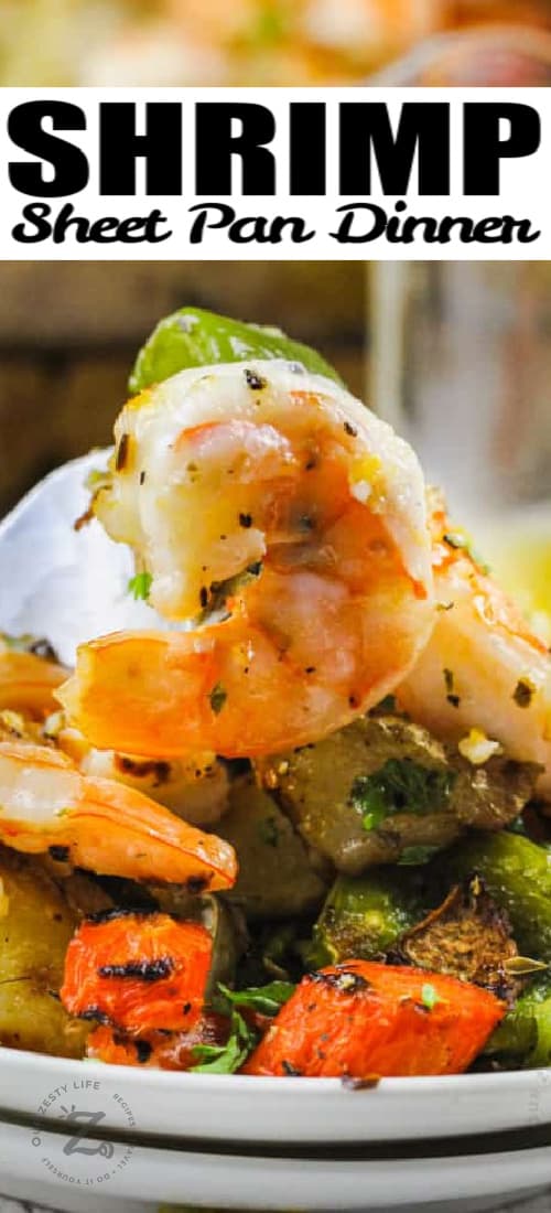 Shrimp Sheet Pan Dinner on a plate with a fork full with a title
