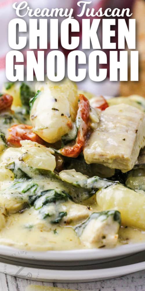 close up of plated Creamy Tuscan Chicken Gnocchi with writing