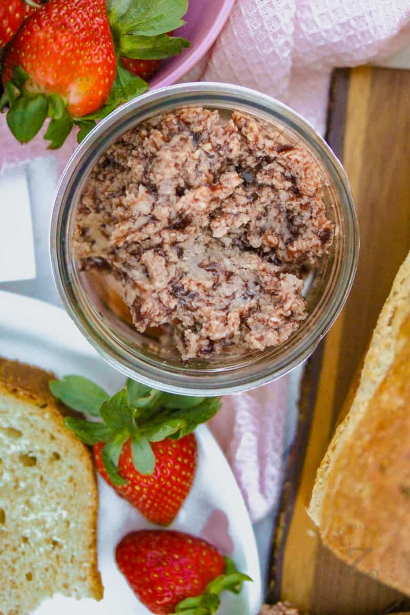 jar of Strawberry Butter with a plate of strawberries and bread beside it