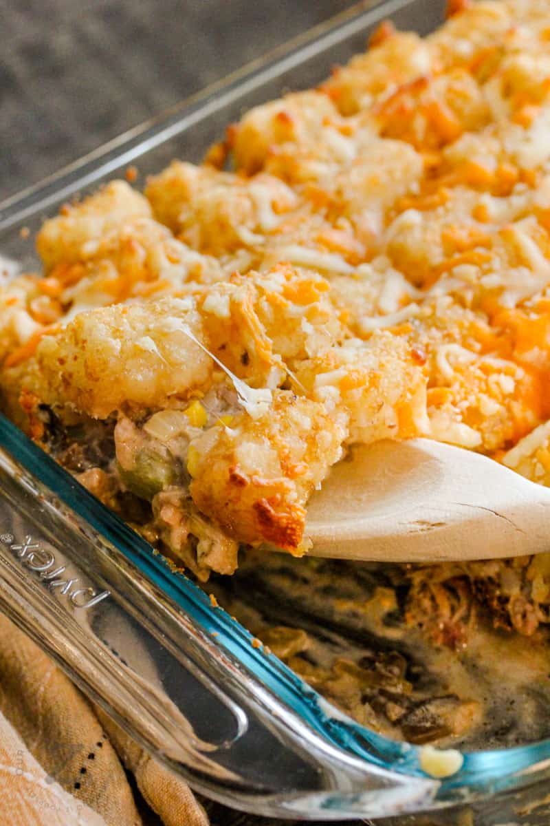 Leftover Pulled Pork Tater Tot Casserole with a wooden spoon