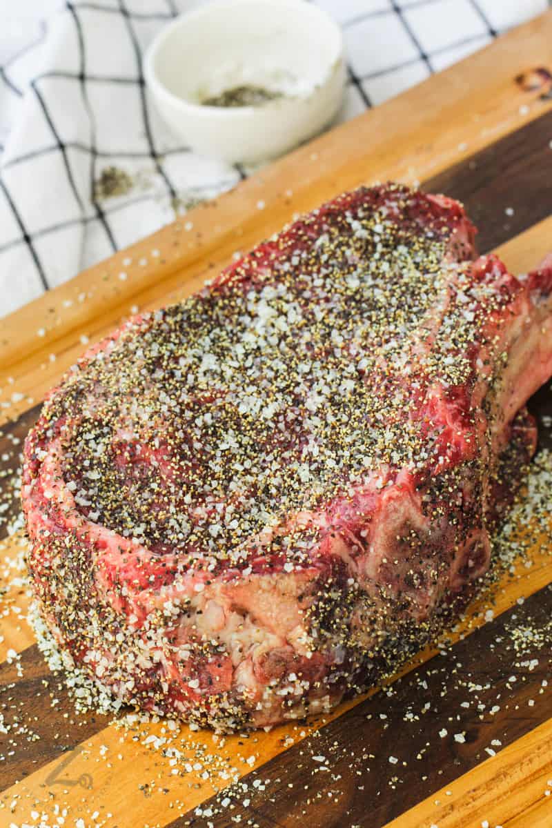 seasoned Tomahawk Ribeye Steak on a cutting board