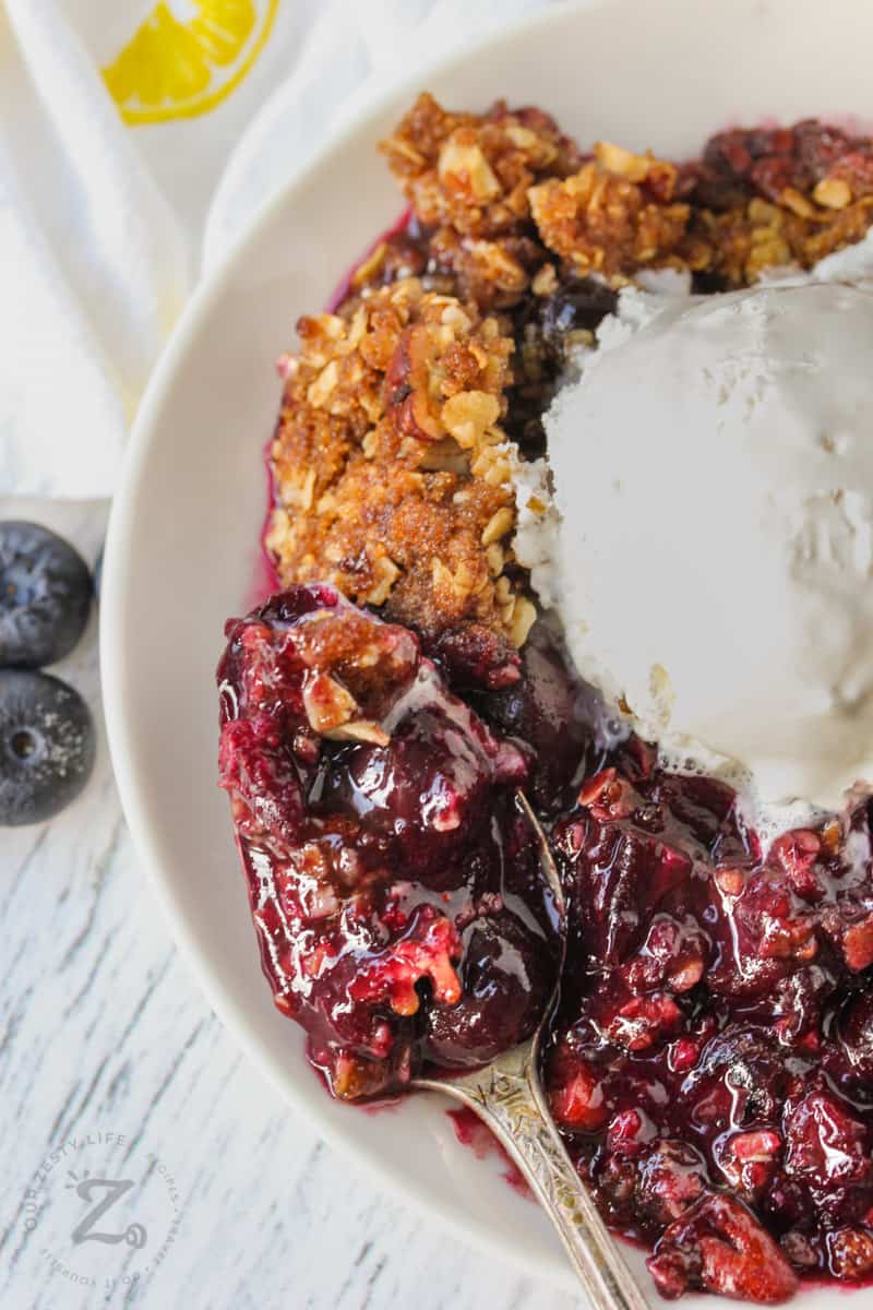 close up of Blueberry Crisp with a spoon