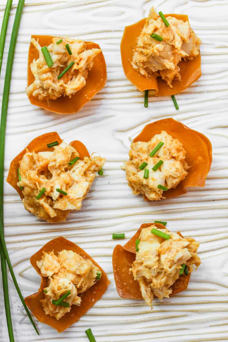 Six prepared chicken wonton cups garnished with chives