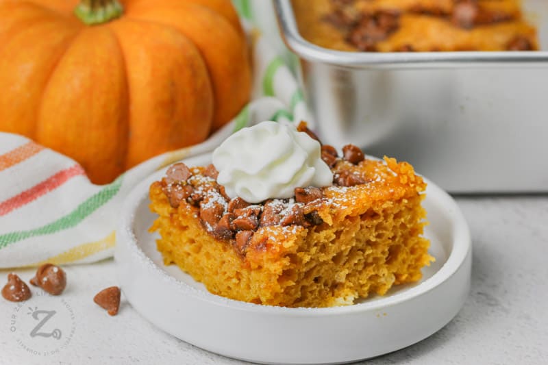 Easy Pumpkin Bars Recipe on a white plate with a dollop of whipped cream on top