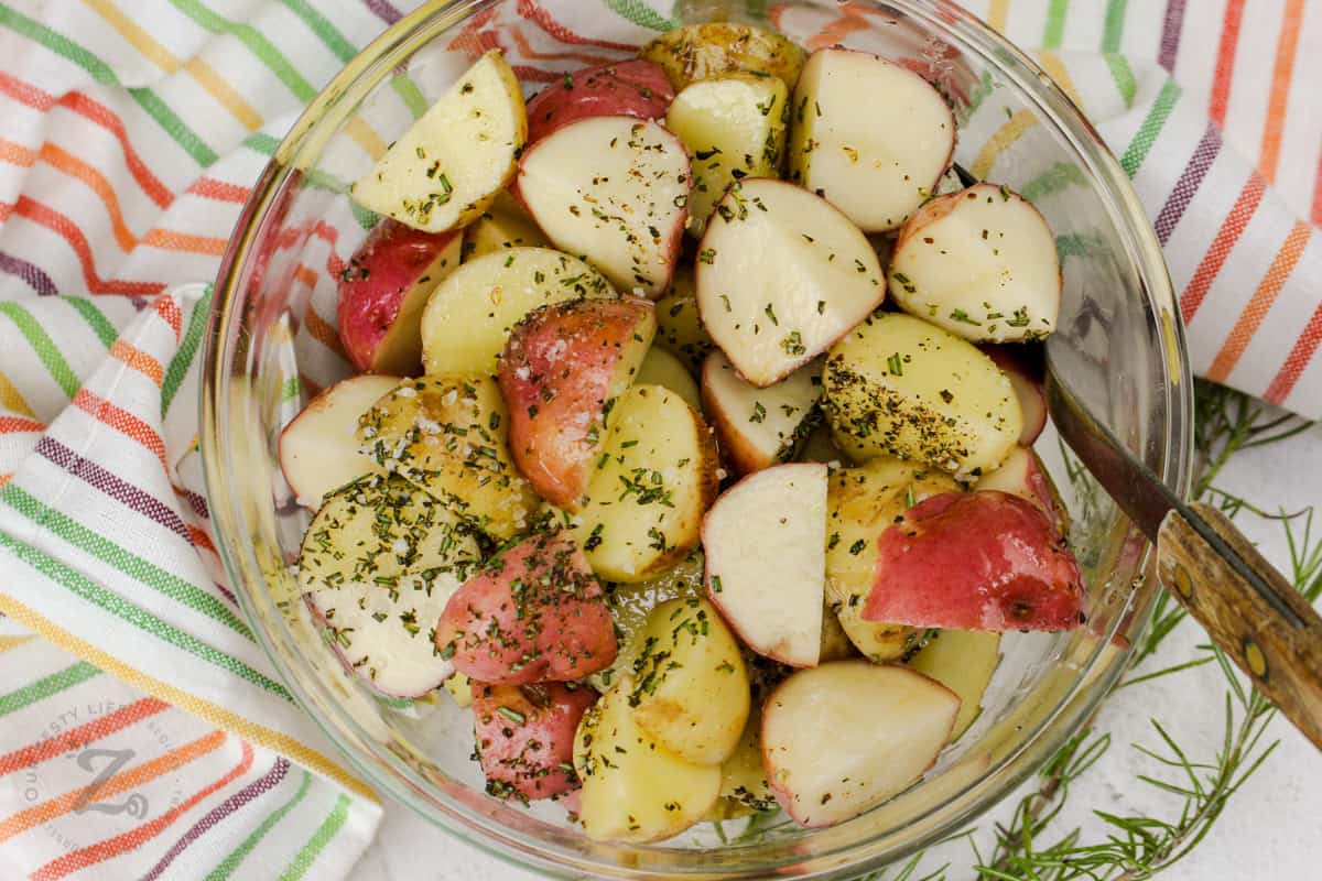 mixing Rosemary Potatoes ingredients in bowl