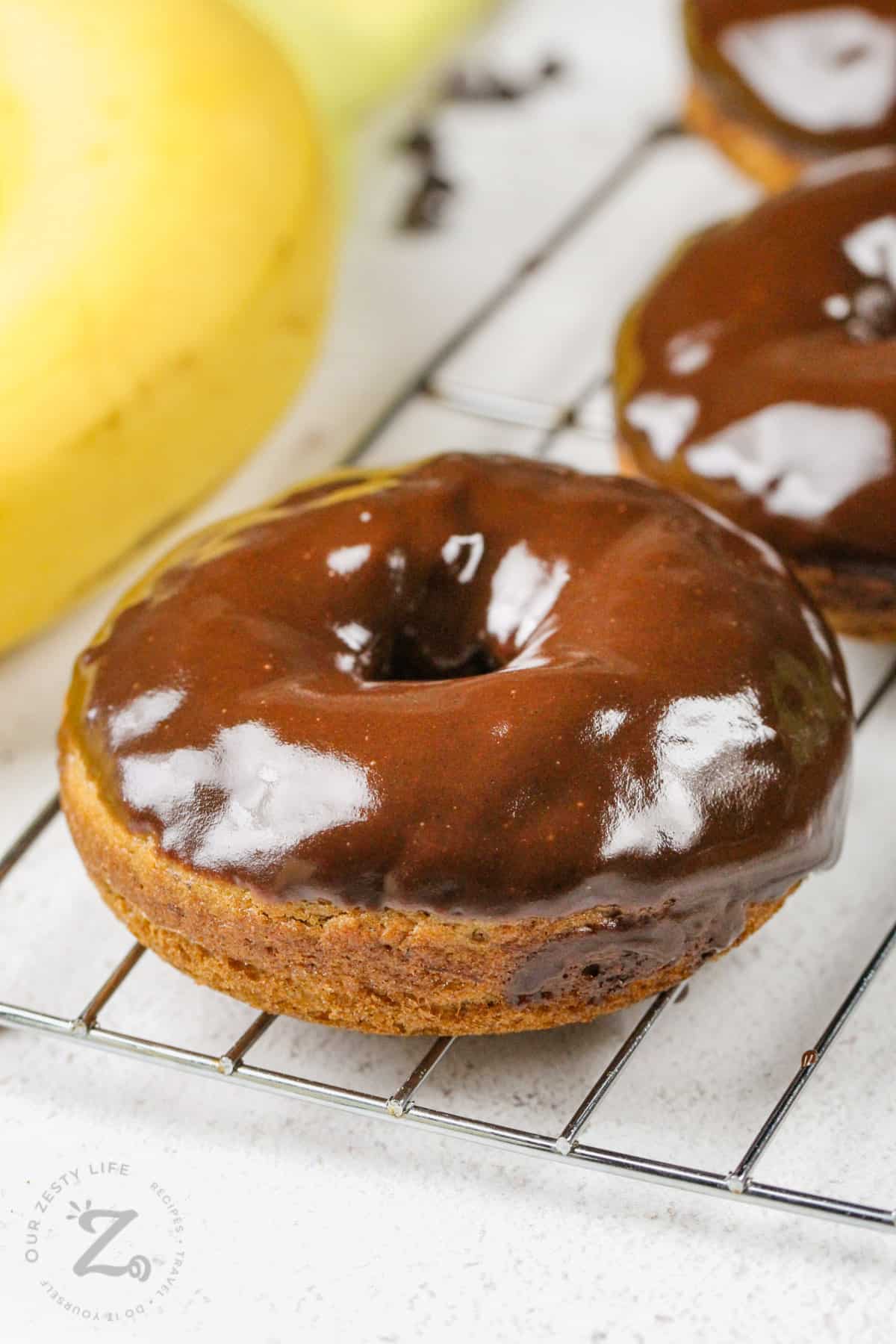 close up of Banana Donuts with Chocolate Glaze on a cooling rack