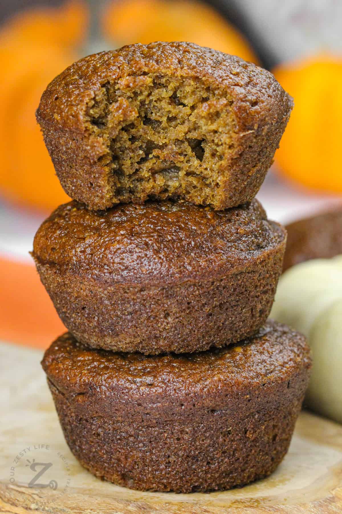 stack of Pumpkin Pie Muffins with a bite taken out of the top one