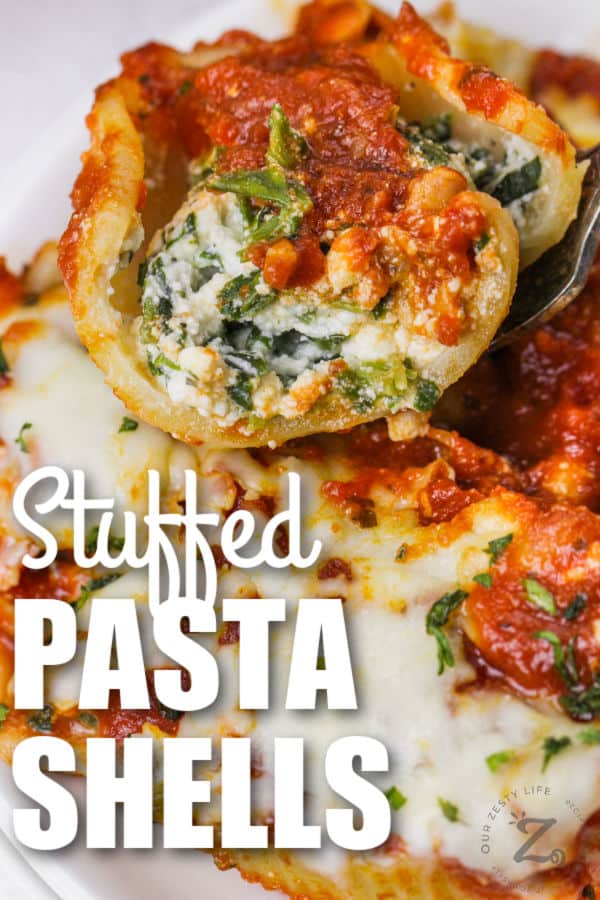 Classic Stuffed Shells on a fork with writing