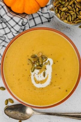 top view of bowl of Pumpkin Soup and bowl of seeds
