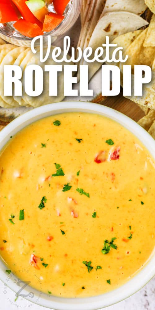 top view of Velveeta Rotel Dip in a bowl with vegetables and chips with writing