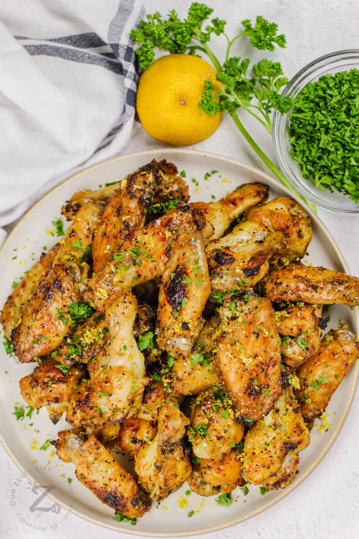 cooked Lemon Pepper Chicken Wings on a plate with garnish