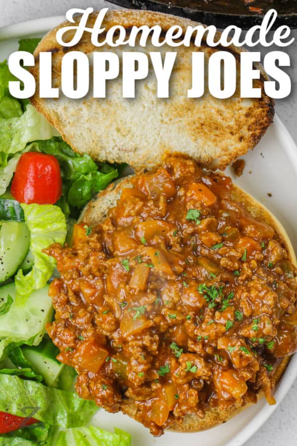 open Homemade Sloppy Joes with salad on a plate with writing