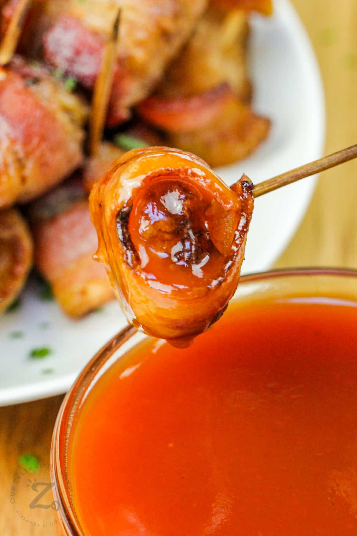 dipping Bacon Wrapped Water Chestnuts in sauce