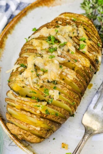 Hasselback Potatoes on a plate with a fork