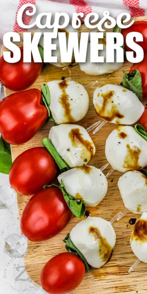 top view of Caprese Skewers on a wooden board with writing