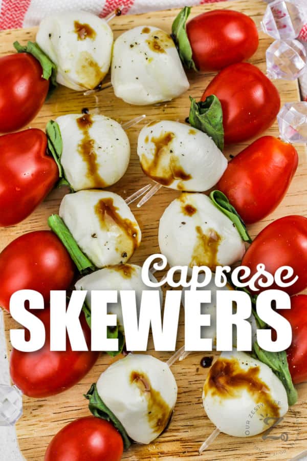 Caprese Skewers on a wooden board with a title