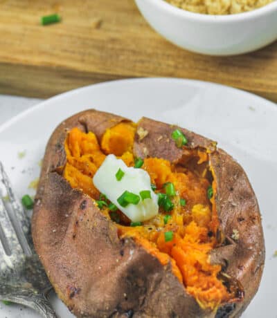Air Fryer Baked Sweet Potato on a plate with sour cream