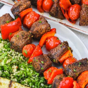 Beef Kabobs on a plate with salad
