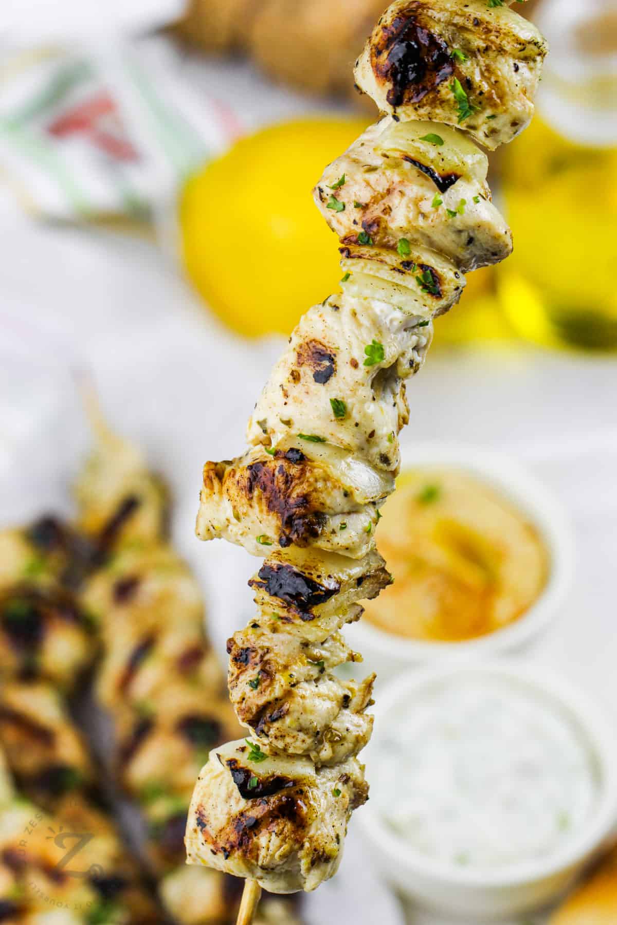 cooked Chicken Souvlaki with dips in the back