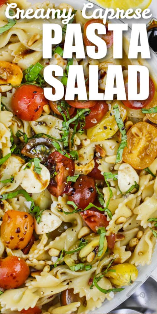 mixed Caprese Pasta Salad in a bowl with writing