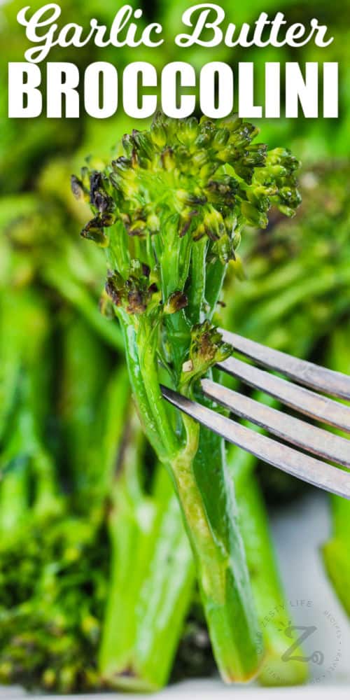 close up of Sauteed Broccolini on a fork with writing