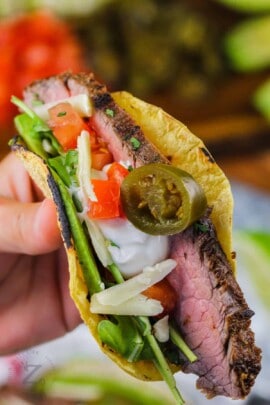 Flank Steak Tacos with jalapeños , cheese , tomatoes and sour cream