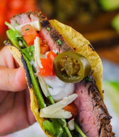 Flank Steak Tacos with jalapeños , cheese , tomatoes and sour cream