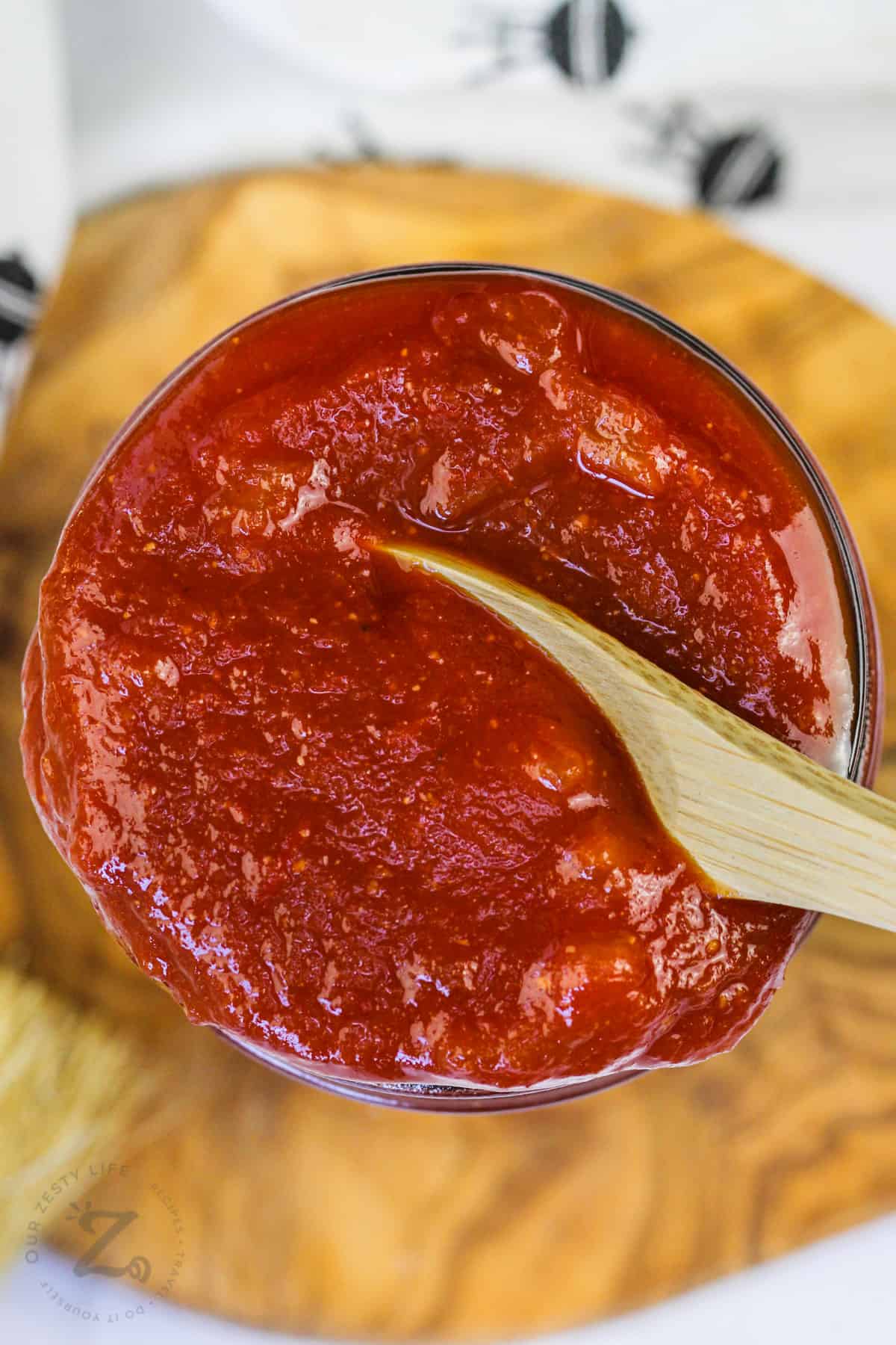 jar of Homemade Barbecue Sauce with a wooden spoon