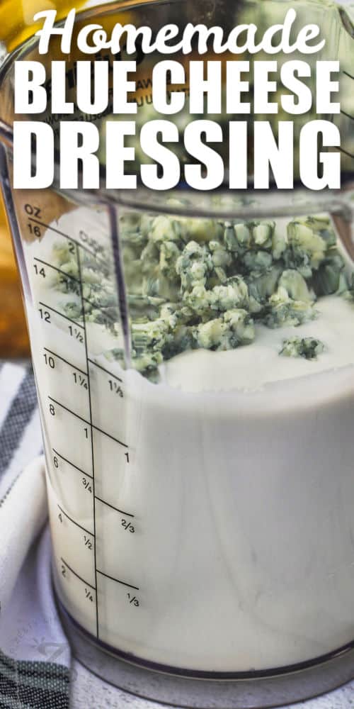 adding blue cheese to jar of dressing to make Blue Cheese Dressing with writing
