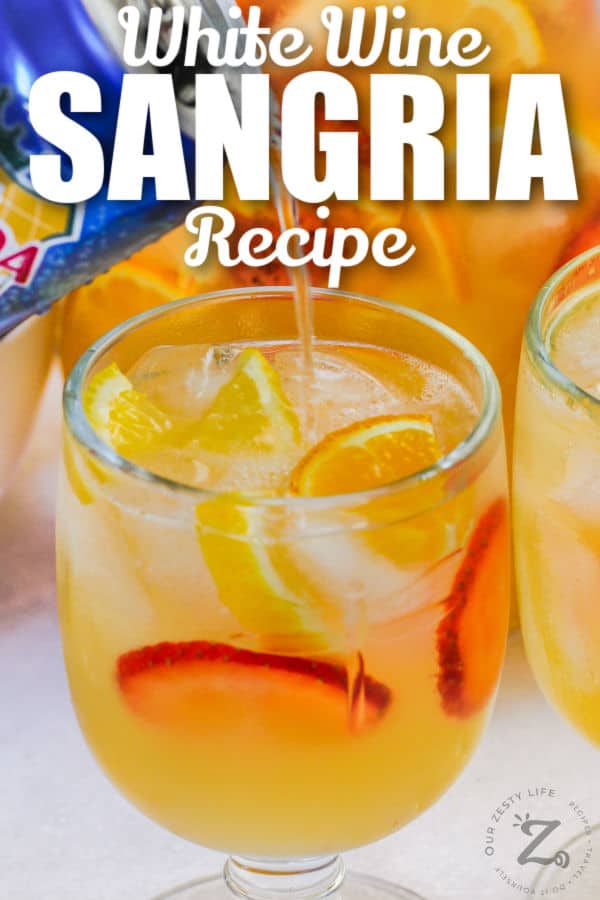 pouring club soda into White Wine Sangria with writing