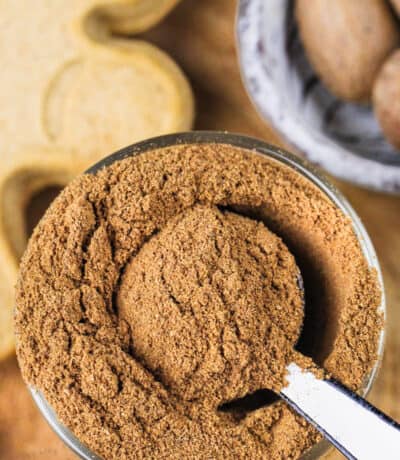 jar of Gingerbread Spice with gingerbread cookie in the back
