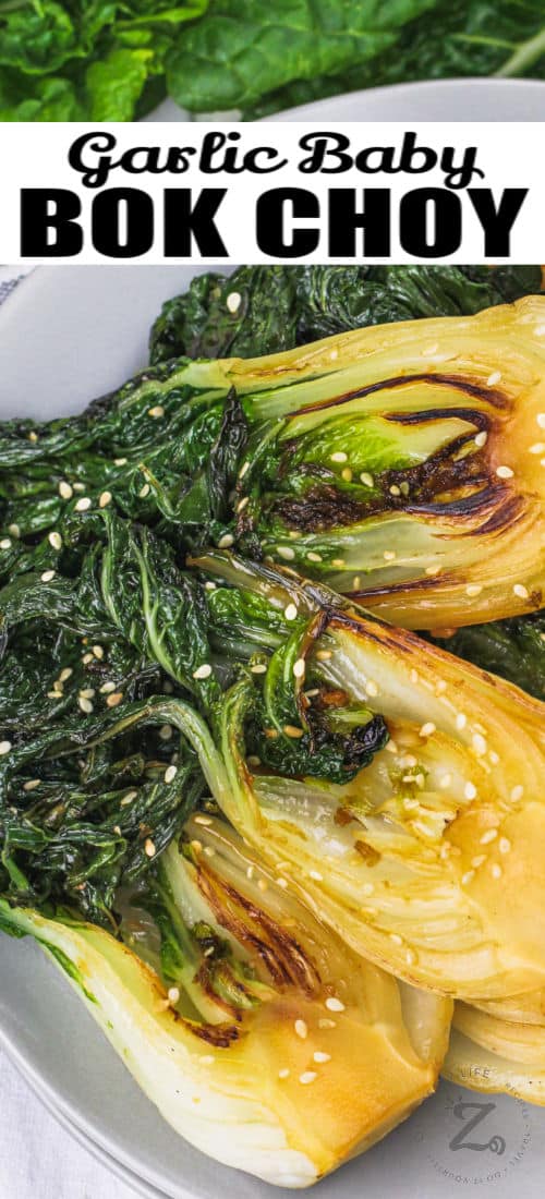 garlic baby bok choy in a white serving bowl, garnished with sesame seeds, with a title
